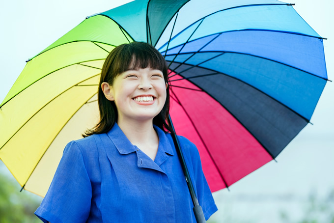 カラフルな傘を差している笑顔の女性