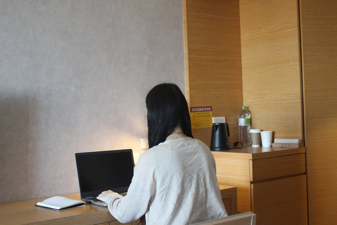 個室でパソコンを操作する女性