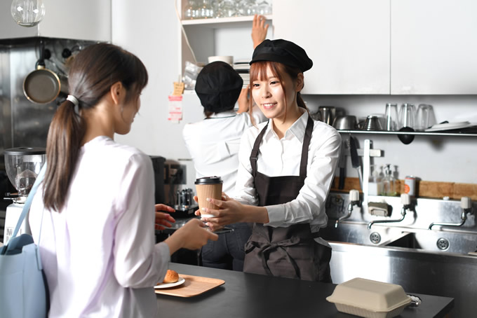 カフェで働く茶髪の女性